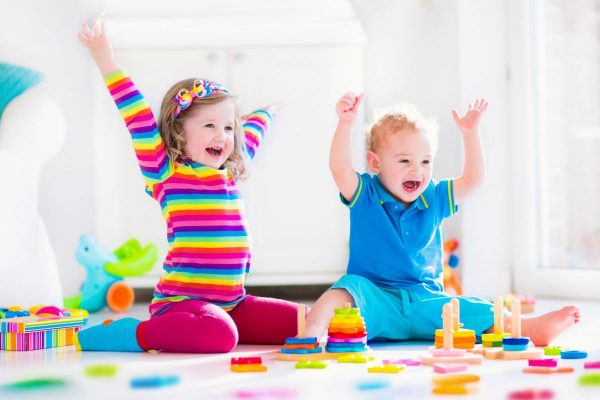 39757261 - kids playing with wooden toys. two children, cute toddler girl and funny baby boy, playing with wooden toy blocks, building towers at home or day care. educational child toys for preschool and kindergarten.